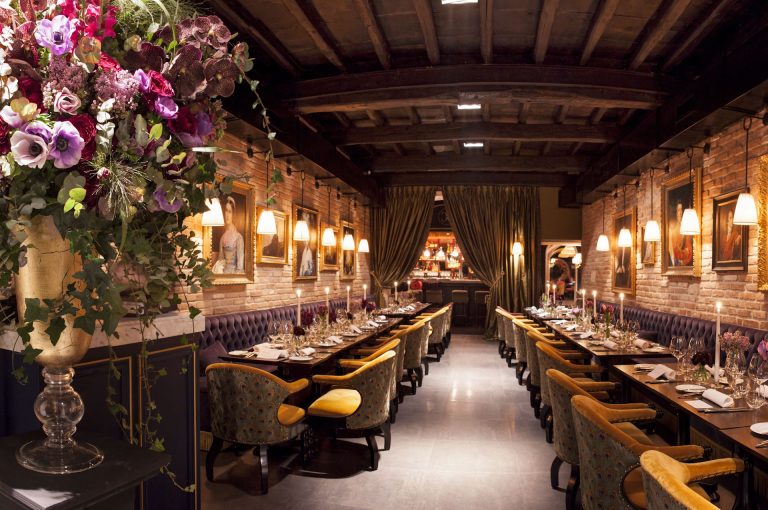 Main dining room with paintings and floral arrangements at Casa Coppelle