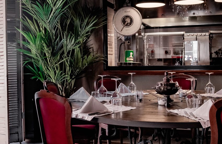 Round dining table beside the open kitchen at El Porteno Teatro Valle