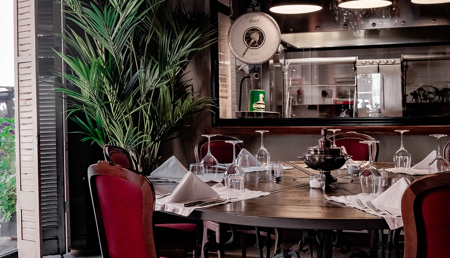 Round dining table beside the open kitchen at El Porteno Teatro Valle