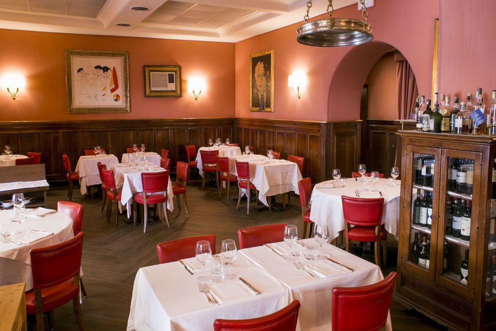 Dining room with red chairs at Dal Bolognese Roma