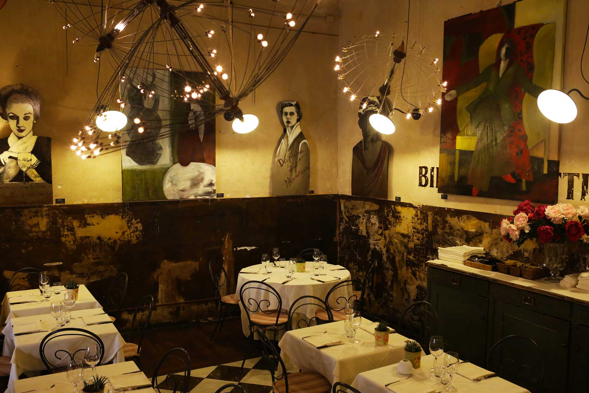 Dining room with artworks and pendant lights at Babette