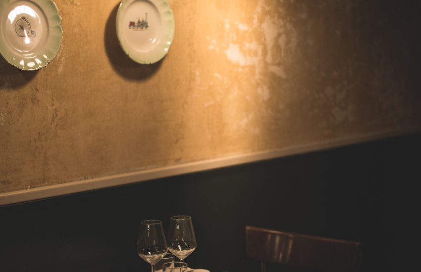 Intimate table beneath a wall lamp at Osteria delle Coppelle