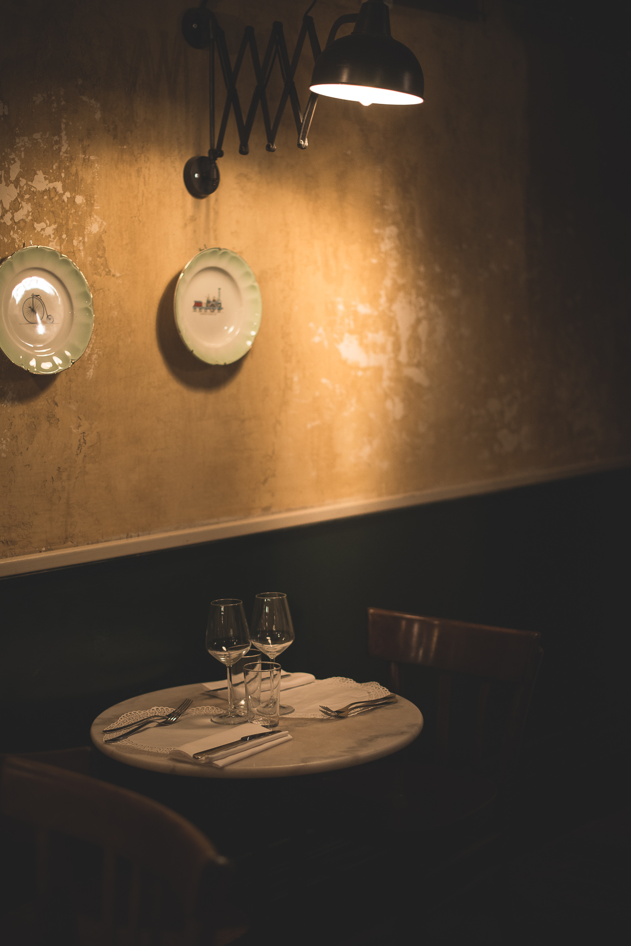 Intimate table beneath a wall lamp at Osteria delle Coppelle