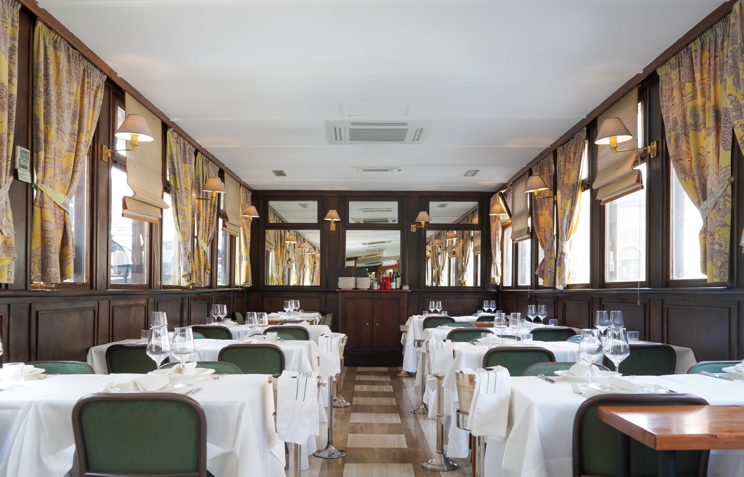 Bright dining room with green chairs at Ai Piani