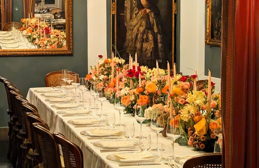 Dining room with chandeliers and a floral table setting at Al Ceppo