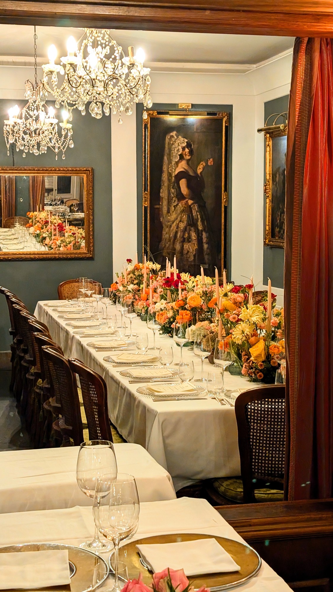 Dining room with chandeliers and a floral table setting at Al Ceppo